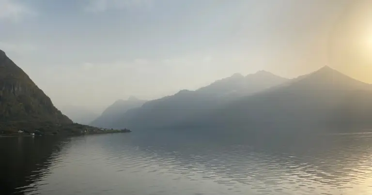 Utsikt utover fjord omkranset av bygd og fjell